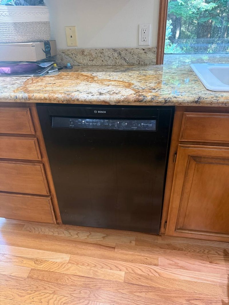 Black Bosch dishwasher under a granite counter in a Gig Harbor kitchen